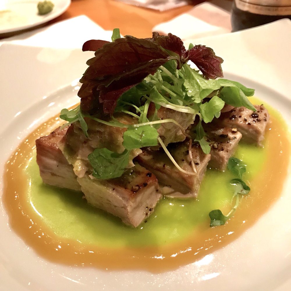 Seared fish on a green sauce, topped with herbs