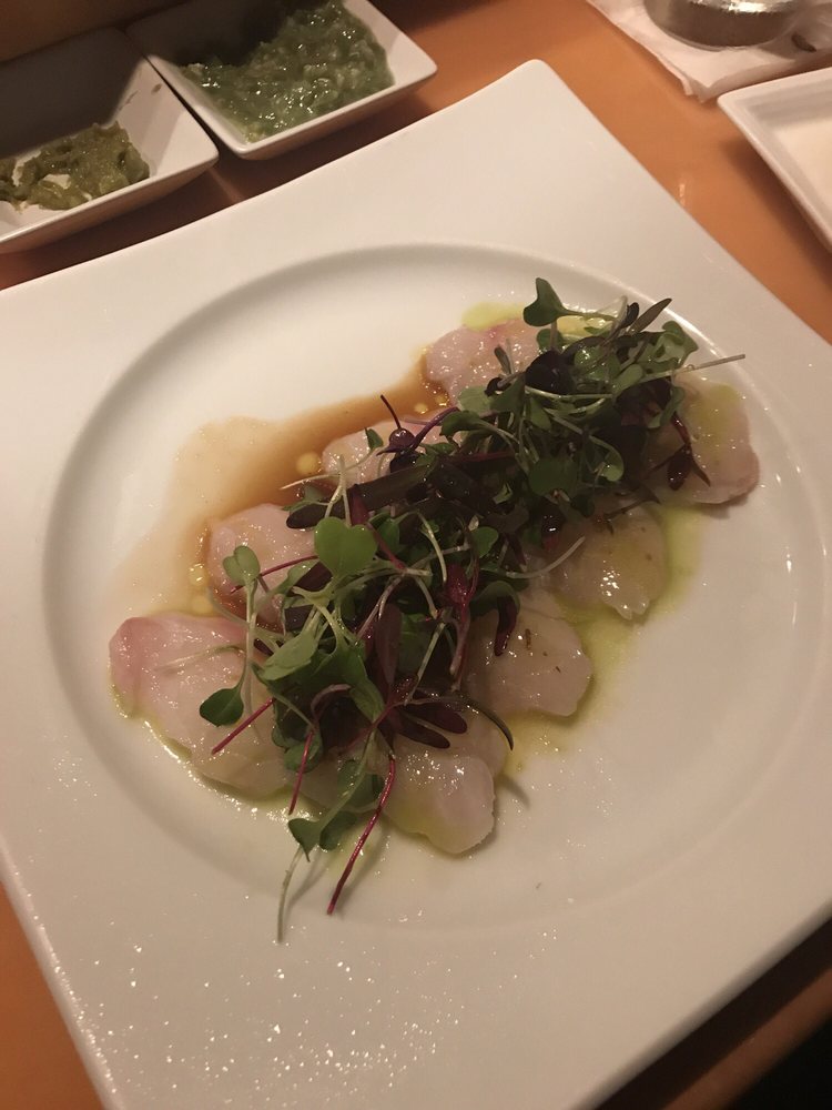 Thin-sliced white fish carpaccio with greens